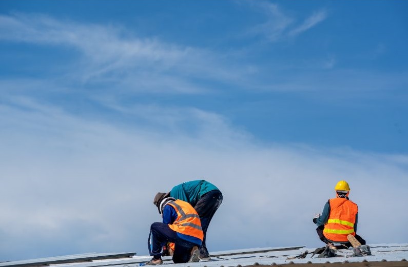 Roofers working at sunset — quality craftsmanship